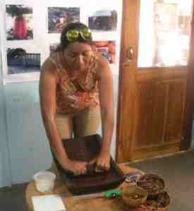 Jesucita trying her hand at cacao grinding